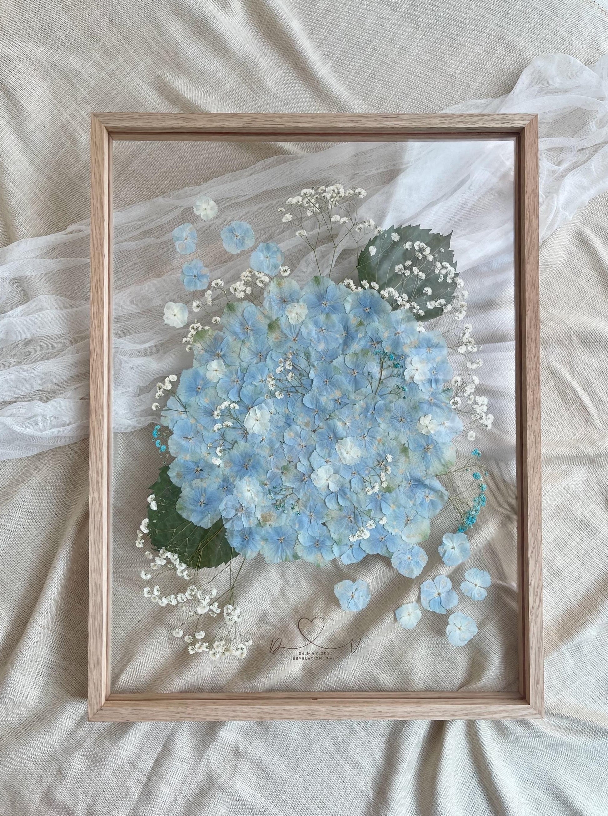 A2-sized Pressed Flower Frame with blue hydrangea, framed with natural wood