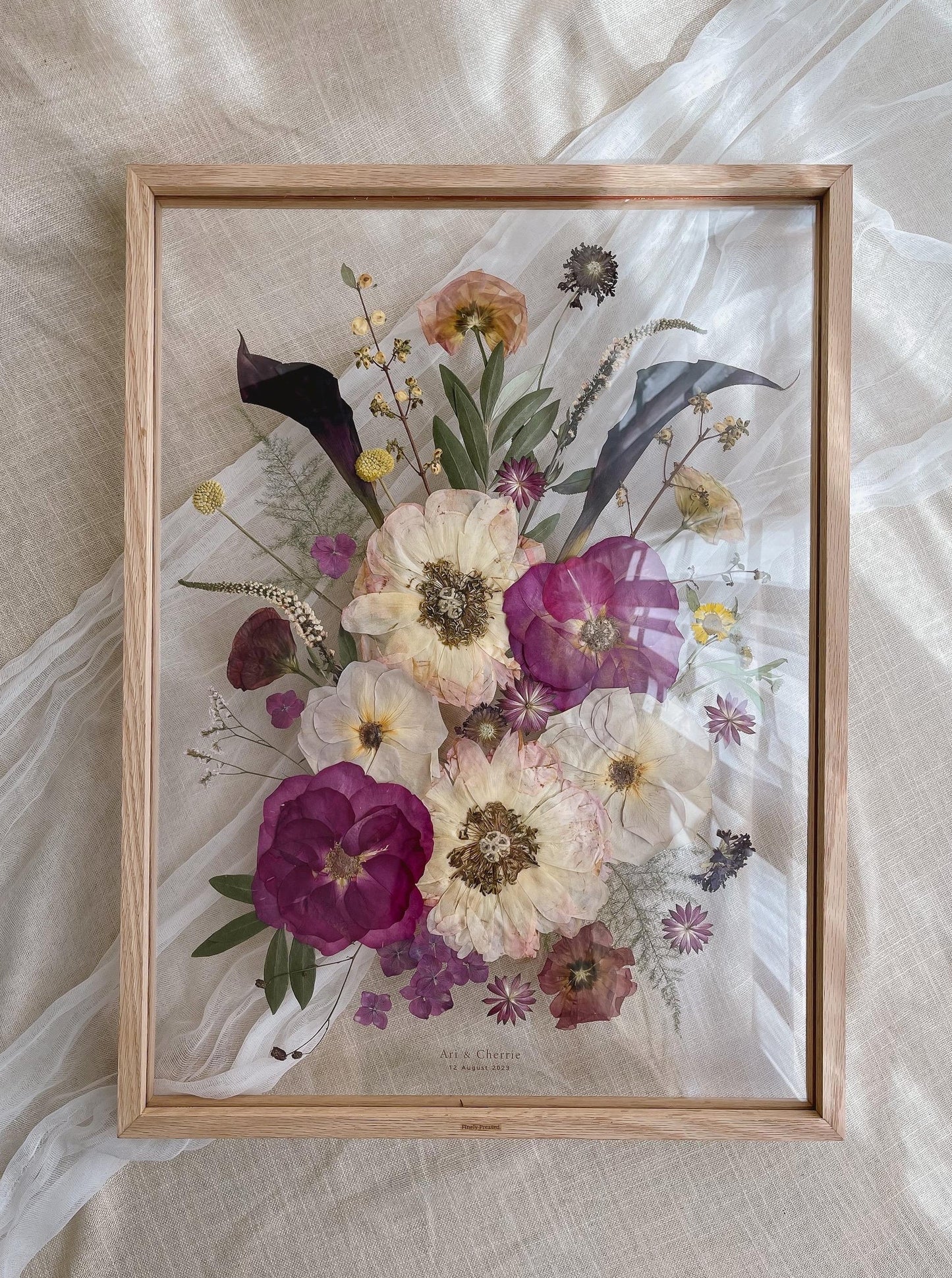 A2-sized Pressed Flower Frame with red and pink flowers, framed with natural wood